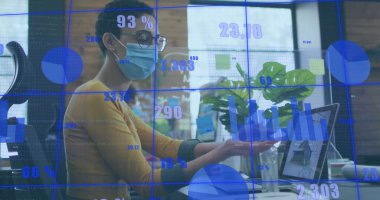 Ofisteki tablette, dizüstü bilgisayar ve gözlüklü sarı üstten izleme verileri olan maskeli bir profesyonel. Kurumsal, analitik, modern, üretkenlik, teknoloji, çalışma alanı, iş