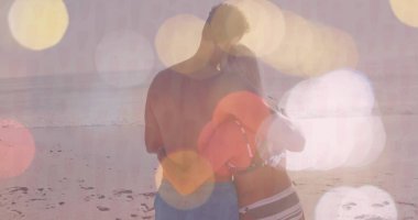 Yüzme şortu giyen, gün batımında kumlu sahilde bikinili kırmızı şişme yüzük tutan çift. Aşk, eğlence, sükunet, sükunet, açık hava, tatil, siluet