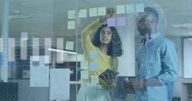 Yapışkan not, iş kıyafetleri içinde beyin fırtınası planı ofisteki cam tahtaya, tabletle birlikte. İşbirliği, yenilik, strateji, takım çalışması, yaratıcı, modern, dijital