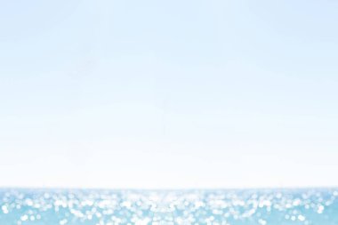 Okyanus yüzeyi, düz dizaynlı, soluk mavi gökyüzündeki yumuşak dalgalara güneş ışığını yansıtıyor. Su, sükunet, sükunet, minimalizm, doğa, ahenk, rahatlık