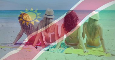 Parlak bikiniler ve güneş şapkaları takan dört arkadaş plajda havluların üzerinde oturmuş turkuaz denize hayranlık duyuyorlar. Plaj, tatil, rahatlama, güneşlenme, açık hava, arkadaşlık.