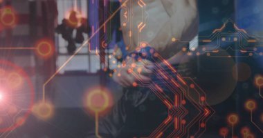 Gömleksiz boksör pantolonu ayarlıyor, spor salonunda kum torbası ve dijital kaplamayla baskılı kemeri bağlıyor. Sporcu, fitness, dinamik, modern, güç, disiplin, eğitim