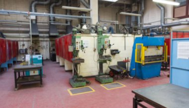 Yeşil matkaplar düz dizayn atölyesinde duruyor, mavi basın ve kırmızı bölümler sergileniyor. Sanayi, makine, atölye, imalat, güvenlik, teknik, mühendislik