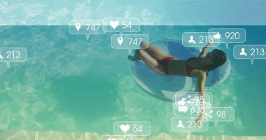 Yüzme havuzunda yüzen kırmızı bikinili bir Çinli kadın sosyal ikonlarla birlikte yüzüyor. Tatil, dinlenme, rahatlama, açık hava, canlı, eğlence, yaşam tarzı.