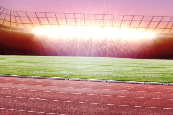 Boş stadyum, projektörlü kırmızı şeritler ve düz dizayn çimenlik alanlar sergiliyor. Atletizm, spor, yarışma, açık hava, arena, fitness, eğitim