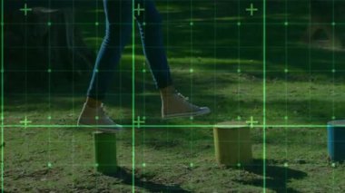 Kırmızı silindire basan bir kadın, yeşil ızgaralı renkli kütüklerle sağlık eğitimine rehberlik ediyor. Denge, çeviklik, fitness, açık hava, atletizm, aktivite, egzersiz