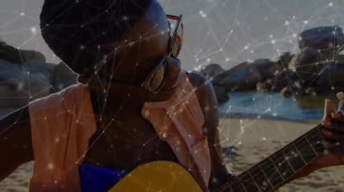 Düşen dijital teknoloji, gitarı kuma yerleştiren ve melodik akorları gösteren bir kadının üzerini örtüyor. Müzik, sükunet, doğa, akustik, ilham, açık hava, yaşam tarzı