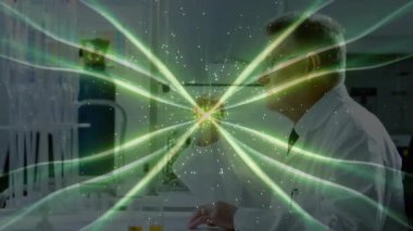 Laboratuvar bankında yazı yazan kıdemli bilim adamı şeffaf ekranda parlayan yeşil parçacık alanı üretiyor. Araştırma, yenilik, deney, teknoloji, görselleştirme, bilim, keşif