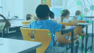 Asyalı çocuk görüş alanına giriyor, kameraya gülümserken sınıf arkadaşı eğitimde kalem çeviriyor. Çocuklar, sınıf, eğitim, öğrenme, takım çalışması, çeşitlilik, okul