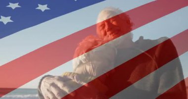 Su kenarında ortağı olan yaşlı bir adam, vatanseverlik haracını başlatan Amerikan bayrağı. Emeklilik, arkadaşlık, nostalji, dinginlik, vatanseverlik, deniz kenarı, sıcaklık