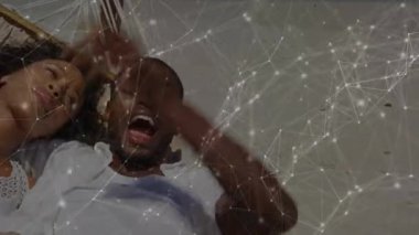 Güneşli sahil güvertesindeki hamağa yerleşen çift kahkahalarını paylaşarak seyahat etmeye başlıyor. Romantizm, rahatlama, rahatlama, açık hava, güneş ışığı, arkadaşlık, sükunet