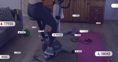 Kadın spor salonuna giriyor ve bisiklete biniyor, canlı istatistikleri yükseltmek için pedal çeviriyor, aynı zamanda ekran bisikletçisine de uyuyor. Fitness, egzersiz, sanal, motivasyon, sağlık, performans, teknoloji