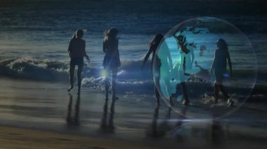 Ayak bileklerinden çıkan veri ışınları dünya teknolojisine girdikten sonra beş kadın kıyı şeridinde yürüyor. Grup, arkadaşlık, bağlantı, dijital, teknoloji, okyanus, gün batımı