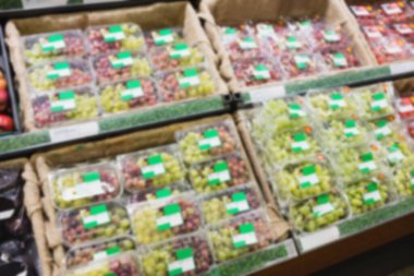 Süpermarkette satılmak üzere plastik kutularda organik meyveler