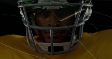 Yüzü maskeli kask takan, koyu renkli sarı formalı yeşil çizgili odaklanan oyuncu. Sporcu, spor, dinamik, gelecekçi, ekipman, rekabet, performans