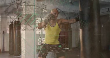 Boksör boks salonunda ağır torba yumrukluyor, sarı askılı tişört, siyah eldiven ve veri örtüsüyle. Spor, antrenman, güç, atletik, spor, performans, motivasyon