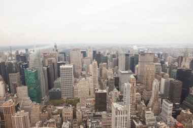 Panorama, bulutlu gökyüzünün altında, kuleleri ve antenleri olan yoğun bir ufuk çizgisi gösteriyor. Metropolitan, şehir manzarası, şehir manzarası, modern mimari, hava manzarası, ticari bölge, altyapı