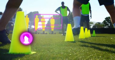 Ayakta duran sarı kozalaklar sahada, futbol oyuncuları macenta örtülerinin yanında pratik yapıyor. Spor, takım çalışması, antrenman, çeviklik, spor, açık hava, strateji