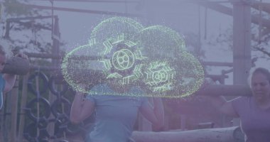 Omuz kirişli beş kadın spor giyimli ağaçlık engelli parkurda vites hologramıyla ilerliyorlar. Fitness, takım çalışması, vahşi doğa, güç, dijital, dayanıklılık, açık hava