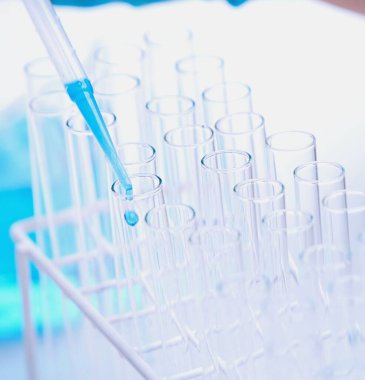 Bilimadamı laboratuvarda kimyasal çözeltiye bakıyor.