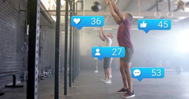 Performans tişörtlü üç adam, CrossFit spor salonunda çan kulesiyle ilaç topu atıyorlar. Dayanıklılık eğitimi, fitness ortamı, atletizm, egzersiz oturumu, dayanıklılık, fonksiyonel egzersiz, takım çalışması