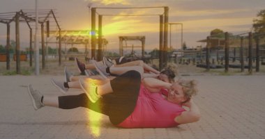 Spor giyim bölümünde spor giyinen altı kadın spor salonunda spor yaparken, metal çerçeveli bisiklet mekiği çekiyorlar. Açık hava, fitness, grup, sağlık, aktif, spor, motivasyon