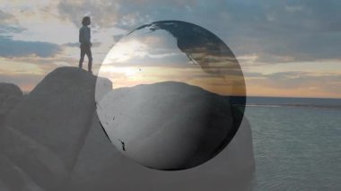 Gün batımında kayadaki kadın, dönen dünya örtüsü, akıllı telefonu kaldırmak ve iş görüşmesine başlamak. Macera, keşif, bağlantı, farkındalık, dinginlik, açık hava, teknoloji