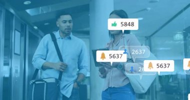 İş arkadaşları lobide yürüyor, tablet verilerini inceliyor ve artan uyarıları görüyorlar. Teknoloji, iletişim, işbirliği, modernlik, profesyonel, kurumsal, dijital