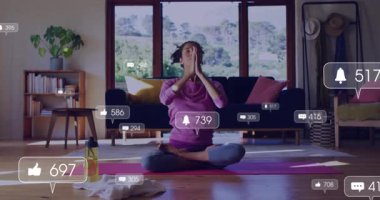 Yoga koçu avuç içlerini meditasyona yerleştiriyor, zil ve yorum gösteriyor. Farkındalık, sağIık, sükunet, dinginlik, iç mekan, yaşam tarzı, ruhsal