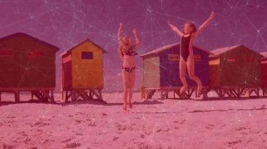 Sahildeki kulübelerden kollarını kaldırıp üç kez zıplayan kardeşler, sağlık için el kol hareketi yapıyorlar. Oyuncu, dostluk, canlılık, açık hava, renkli, enerjik, boş zaman