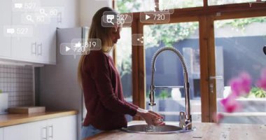 Musluk altında ellerini yıkayan bir kadın sosyal medya bildirimlerinin yükselişini ve nişanı gösteriyor. Modern, minimalist, sosyal, dijital, yaşam tarzı, yerli, canlı