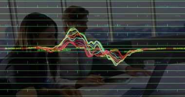 İz sürme platformunda çalışan, dizüstü bilgisayarda yazan, dalga boyunda zirve yapan ve teknik gösteride düzleşen bir kadın. İşbirliği, takım çalışması, veri analizi, dijital arayüz, ofis ortamı, üretkenlik, yenilik