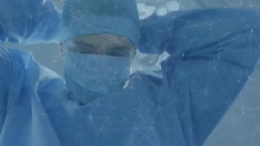 Cerrahlar kameraya bakıp sonra da parlak ışıkların altında kafaya monte edilmiş loupe 'u ameliyata hazırlıyor. Tıbbi, sağlık, kesinlik, steril, klinik, profesyonel, yenilik