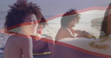 Seyahat reklamı, plaj paspasında gülen grubu gösteriyor. Bayrak örtüsü de 4. arkadaşın girmesiyle dönüyor. Plaj, arkadaşlık, rahatlama, canlı, açık hava, yaşam tarzı, toplum