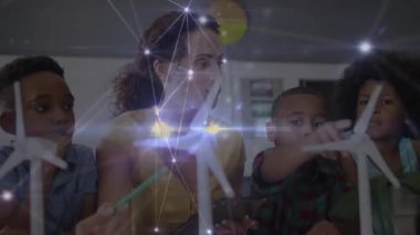 Anne tableti tıklatıyor, türbin şemaları gösteriyor, çocuklara BTMM için dönen bıçaklar gösteriyor. Eğitim, aile, teknoloji, yenilik, bilim, öğrenme, modern