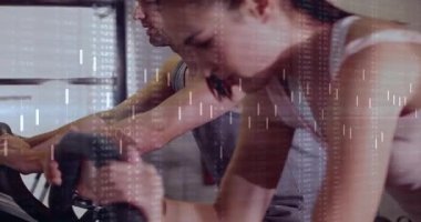 Antrenman yapan çift dijital izleme performansı altında pedal çeviriyor. Fitness, takım çalışması, motivasyon, teknoloji, sağlık, dayanıklılık, dostluk