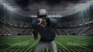 Yakalayıcı, defans oyuncusu yarda kazancını engellerken topu yay göstererek yakalıyor. Atletizm, takım çalışması, yoğunluk, rekabet, stadyum, aksiyon, spor