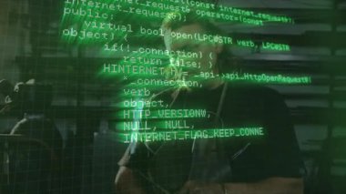 Yazılım algoritmaları kaydırılırken atölyede duran adamın üzerinde yeşil kod var. Teknolojik, endüstriyel, veri, programlama, siber güvenlik, soyut, kök