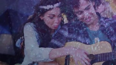 Kadın, erkeğin fretboard 'una elini koyuyor. Kamp alanında ışıltılı gitar akoru alıştırması yapıyor. Romantik, samimi, sakin, uyumlu, rahat, organik, nazik