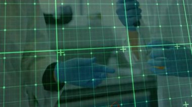 Yeşil şebeke, turuncu sıvıyı emen ve dağıtan pipet seçen bilim adamını kaplıyor. Laboratuvar, araştırma, kesinlik, yenilik, bilim, teknoloji, deney