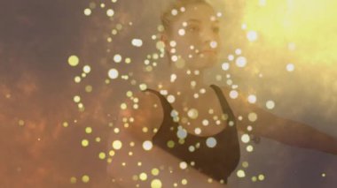 Yoga sırasında dua eden kadın, ışık meditasyonu tetikledikten sonra altın kıvılcımlar şeklinde kıvrılır. Meditasyon, maneviyat, dinginlik, minimalizm, sağlık, dans, uyum.