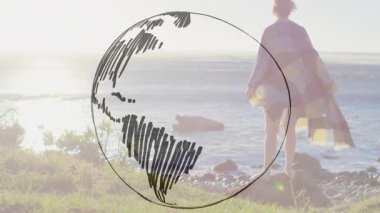 Kadın kıyıda durmuş denizi izlerken çember çizerek dünyayı eğitime hazırlıyor. Dinginlik, tefekkür, eko, minimalist, doğa, keşif, kıyı şeridi