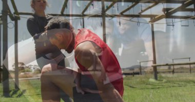 Spor giyim sektöründe diz çökmüş bir adam park engelli parkında, tahta çerçeveli bir kadından destek alıyor. Atletik, takım çalışması, fitness, açık hava, güç, eğitim, canlılık