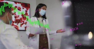 Maskeli doktor tıbbi brifingi başlatıyor, kan monitörüne işaret ediyor. Tıbbi, işbirliği, klinik, araştırma, analitik, teknolojik, profesyonel