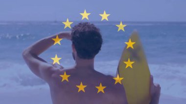 Sörfçü, gün ortası güneşini kalkan alarak kollarını kaldırıyor ve spor dersinde gelen dalgalar için ufku tarıyor. Plaj, okyanus, sörf, su, kıyı şeridi, spor, macera