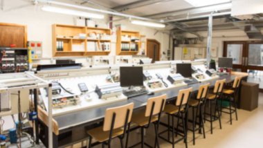 Masasında bilgisayarlar olan aydınlatılmış toplantı odasının içi