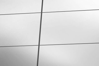 Düz dizayn cam perde cephesinde yansıtıcı paneller ve koyu metal mulyon ızgaralar yer alıyor. Modern mimari, cephe, geometrik, minimalist, kentsel, gösterişli, yapısal