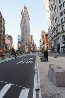 Flatiron Binası 'nda düz dizaynlı sokak bisikletli itfaiye şeridi işaretli, yayalar var. Kentsel, mimari, modern, metropol, yaşam tarzı, canlı, şehir manzarası