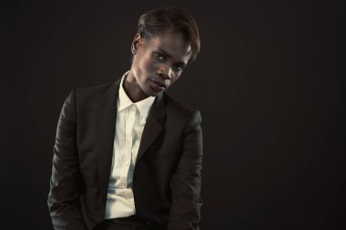 Siyah arka planda oturan kendinden emin bir iş kadınının portresi