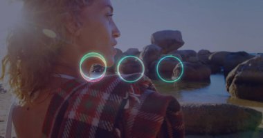 Durgun, sığ sularda granit kayalara bakan, ekose şallı ve mercekli bir kadın. Deniz manzarası, dinginlik, tefekkür, doğal güzellik, bohem, açık hava, rahatlama.